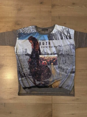 Mönstrad långärmad topp MDG Fashion - Unik tröja med tryck från MDG Fashion. Framsidan har collage med texten 'THE TRUTH EVERYWHERE' och 'EXPLORE', samt motiv av landskap och person. Ärmar och muddar är ribbstickade i brunmelerad ton. Rund halsringning och avslappnad passform. Helt oanvänd 🫶