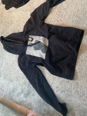 Hodie från the cool elephant  - Svart hoodie med huva och dragsko. På bröstet finns ett rektangulärt tryck i grått och svart med grafiskt motiv. Klassisk ficka  framtill och mjuk och skön bomullsblandning, perfekt för chill dagar. Är storlek S men även xs beror på hur man vill att den sitter men den är inte en stor hodie för S, skriv vid fundering❤️