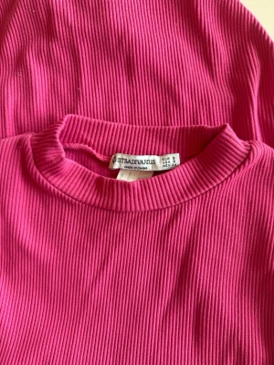 Ribbad rosa body från Stradivarius - Rosa body från Stradivarius i storlek S 💖 Superfin stark rosa färg som verkligen sticker ut – perfekt om du vill ha något som syns! Ribbat material som sitter snyggt och formar kroppen på ett skönt sätt ✨  Passar både till vardag med jeans eller uppklätt med kjol/byxor. En riktig färgklick i garderoben!  I bra skick och redo att användas 💫 Pris kan diskuteras, först till kvarn!