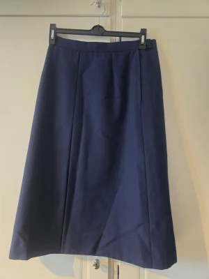 Mörkblå långkjol i ullmix - Vinted mörkblå långkjol med enkel A-linjeformad siluett. Björcks Borås, troligtvis 60-70 tal. Kjolen har diskreta sömmar framtill och stängs med knapp och dragkedja i sidan. Tillverkad i ett mjukt ullblandat material som passar perfekt till både vardagliga och mer uppklädda looks. Skicket är jättefint! 