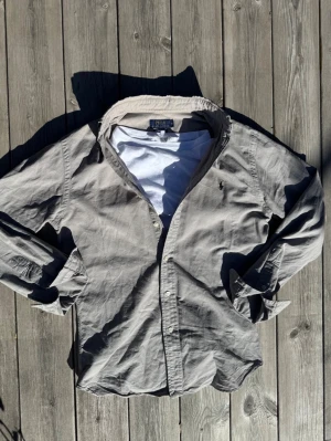 Ralph Lauren skjorta  - Säljer en Ralph Lauren skjorta perfekt till sommaren. Den är beige/grå i färgen och i storlek S slim fit. Skulle säga att den sitter true to size. Inga defekter utöver ett jättelitet hål vid slutet på ärmen, se bild, annars utmärkt skick. Skickar inom en dag med PostNord.