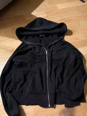 Svart zip hoodie med huva - En svart hoodie med stor huva, den är lite trasig i ärmarna men de går att sy elelr bara använda som den är, pris kan diskuteras 