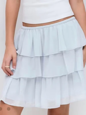 Ljusblå volangkjol med resårmidja - Supersöt ljusblå kortkjol med flera lager volanger och elastisk midja. Kjolen är gjord i ett tunt, skirt material som ger en luftig och flowy känsla. Har aldrig använt, skriv om ni är intresserad💘