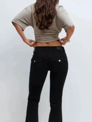 Gina tricot. Svarta bootcut jeans med knapp - Säljer ett par svarta bootcut jeans med knappar på baksidan. Kommer inte till användning för dem är för korta. Strl 36, perfect jeans.