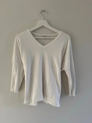 Vit v-ringad topp från Saint - Vit topp från Saint med v-ringning och trekvartsärm. Bra skick och i storlek s men passar andra storlekar också.