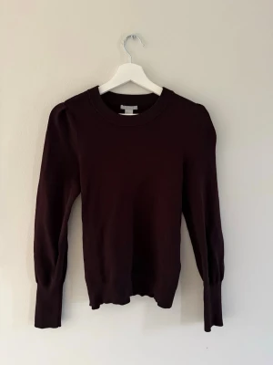 Mörkbrun stickad tröja från H&M - Snygg mörkbrun stickad tröja från H&M med rund halsringning och långa ärmar. Bra skick då den inte kommit till användning och storlek m men passar även s och xs
