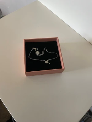 Edblad silver armband - Snyggt och stilrent armband i silverfärg med en liten fågelberlock. Tunn kedja och enkel design som passar perfekt till alla tillfällen.