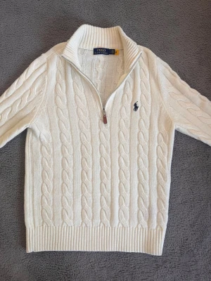 Vit polo Ralph halvzip - ✅ Halvzip   ✅ Färg: vit   ✅ Tjock och varm inuti tröjan   ✅ Använd endast en gång   ✅ Inga fläckar   ✅ Kabelstickad    Hejsan! Jag säljer en snygg tröja som jag fick som present 🎁 och använde på ett bröllop. Den är bara använd en gång och är i väldigt ny  skick.    Så egentligen säljer jag den nästan som helt ny, men för ett lite lägre pris.