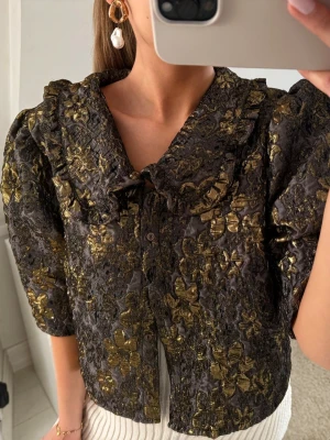 Guldig blus - Suuuupersnygg blus i guld och lite grålila aktig färg😍Lyser så fint i solen och passar de flesta storlekarna beroende på hur man vill att den ska sitta❣️aldrig använd