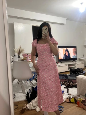 Rosa blommig långklänning - Söt rosa långklänning med vita små blommor och puffärmar. Storlek S