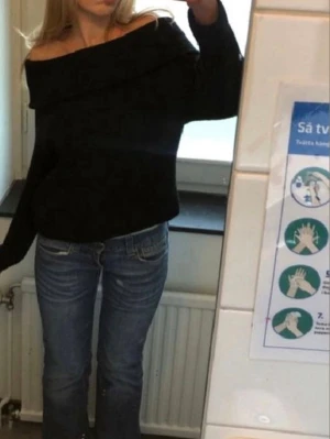 Svart off shoulder stickad tröja - Säljer en svart stickad off shoulder-tröja med långa ärmar och bred ribbad kant upptill. Använd få gånger som ny, i storlek 158/164 men skulle säga att den sitter som S