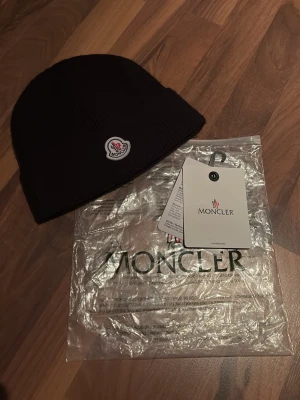 Svart moncler mössa - Riktigt fin! Tror den är äkta (ganska säker) inget fel på den och qr koden skannar!    Skriv vid minsta lilla fundering!