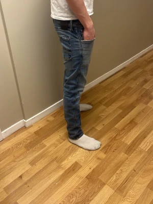Blå slim fit jeans Replay - Säljer ett par blå replay  jeans med snygga kontrastsömmar och klassiska fem fickor. Jeansen har en lätt tvättad look och sitter tajt längs benen för en modern stil. Perfekta till vardagsoutfiten och passar till det mesta.