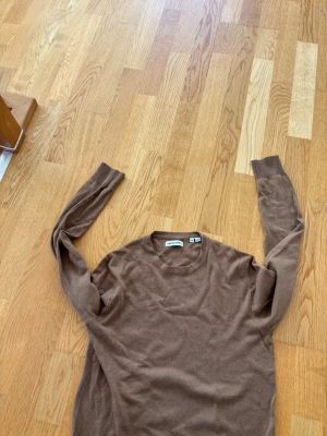 Brun stickad tröja Jack & Jones - Snygg brun stickad tröja från Jack & Jones i storlek XS. Tröjan har rund halsringning och långa ärmar. Perfekt för dig som gillar en enkel och stilren look. Materialet känns mjukt och bekvämt mot huden.