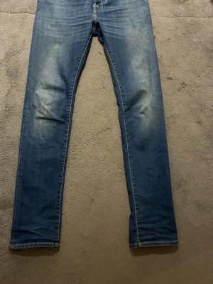 Blå jeans från Jacob Cohën - Säljer ett par klassiska blå jeans från Jacob Cohën med snygg tvätt och raka ben. Jeansen har fem fickor, normal midja och detaljerade sömmar. Tillverkade i mjuk denim som ger en skön känsla och avslappnad look.