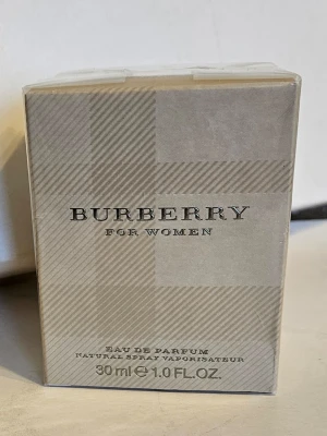Burberry For Women Eau de Parfum 30ml - Burberry For Women Eau de Parfum i en elegant beige kartong med klassiskt rutmönster. Flaskan innehåller 30 ml och är en naturlig spray. En tidlös doft från Burberry som passar dig som gillar exklusiva och feminina parfymer.