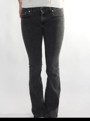 Svarta bootcut jeans med stretch - Snygga svarta bootcut jeans med klassisk femficksmodell och stretchigt material för skön passform. Jeansen har normal midja och subtil tvätt för en cool look. Perfekta till sneakers eller boots för en avslappnad stil.