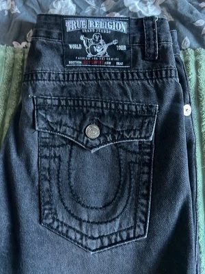 Svarta True Religion Jeans  - Säljer ett par svarta True Religion Jeans. Jeansen har raka ben. Ifall du har några frågor är de bara att fråga på. Jag är aktiv och skickar snabbt.