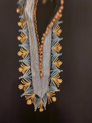 Marockansk klänning med kaftan  - Elegant svart långklänning med tillhörande kaftan med detaljerad blå och guld broderad kant längs halsringning och ärmar. Klänningen har v-ringad öppning och dekorativa broderade mönster som ger en lyxig känsla. Perfekt för dig som vill sticka ut med unika detaljer.