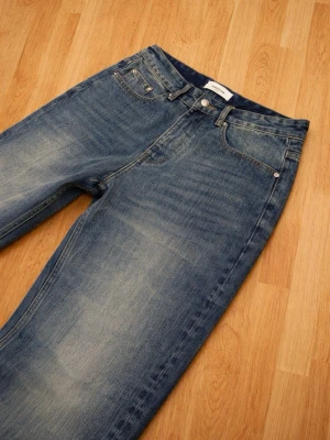 Blå raka jeans från Arket - Säljer ett par blå raka jeans från Arket med klassisk femficksmodell och snyggt tvättad finish. Jeansen har hög midja och är tillverkade i kraftig denim som ger en tidlös look. Perfekta till sneakers eller boots.