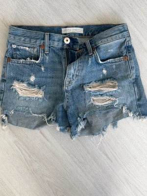 Blå jeansshorts med slitningar  - Säljer ett par blå jeansshorts från Bershka med slitna detaljer. Det är storlek 32 men skulle mer säga 34💗