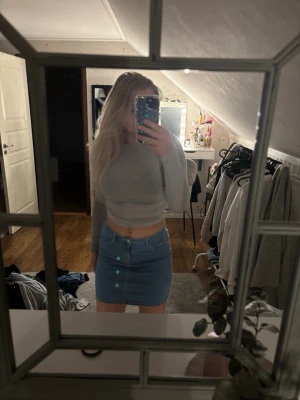 Blå jeanskjol - Säljer en snygg blå jeanskjol. Kjolen är kort och har en klassisk denimlook som passar perfekt till en trendig vardagsstil. Enkel att matcha med olika toppar och sneakers. Storlek 158/164 men passar xs .