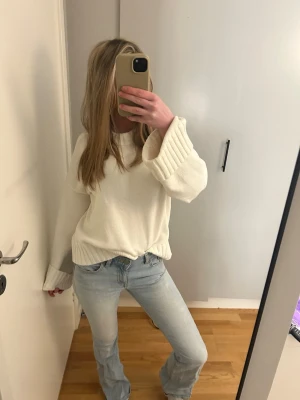 Ljusblå bootcut jeans - Säljer ett par ljusblå jeans med bootcut-modell och låg midja. Jeansen har klassisk femficksdesign och är tillverkade i ett mjukt denimtyg som ger en avslappnad och trendig look. Perfekta till en stickad tröja eller t-shirt.