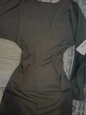 Svart långärmad klänning från Nelly - Säljer en svart, figurnära långärmad klänning från Nelly. Klänningen har en enkel och stilren design med rund halsringning och markerad midja. Perfekt för dig som gillar minimalistisk stil och vill ha en klassisk svart klänning i garderoben. Ny med prislapp kvar, pris kan diskuteras 