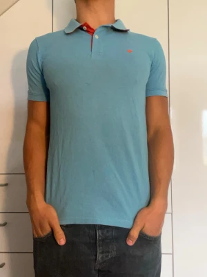 Ljusblå piké från Tom Tailor - Ljusblå piké tillverkad i 100% bomull från märket Tom Tailor. Strl S. Inga defekter. Modellen är 178 cm och väger 77 kg. Hör gärna av dig vid frågor!