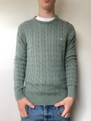Grön kabelstickad tröja från Morris - Modellen på bilden är 178cm och väger cirka 70kg. Nypris är cirka 1600 medans jag säljer den för endast 499kr. Hör gärna av er vid intresse!