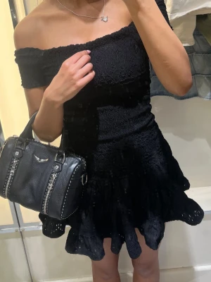 Svart offshoulder klänning - Helt ny!! Supersöt svart kortklänning med offshoulder och volangkant. Klänningen har en figurnära passform upptill med en utsvängd kjol. Perfekt för dig som vill ha en romantisk och trendig look.