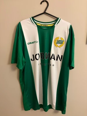 Hammarby matchtröja Craft grön/vit - Säljer en Hammarby IF matchtröja från Craft i storlek M. Tröjan har klassiska gröna och vita vertikala ränder, klubbmärke på bröstet och sponsortryck. Tillverkad i lätt och funktionellt material, perfekt för fotboll eller träning.
