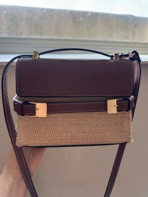 Slutsåld väska från HM - Väska med snygga guldiga detaljer. Köpt från HM och är slutsåld sedan förra sommaren 