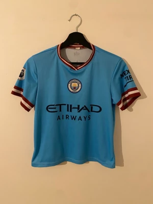 Manchester City matchtröja 22/23 Haaland #9 - Säljer en Manchester City matchtröja 2022/23 med Haaland #9 på ryggen. Tröjan har klubbmärke på bröstet samt tryck på ärmarna. Lätt och ventilerande material, perfekt för fotboll!