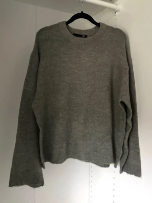 Grön stickad tröja  - Svårt att fånga färgen på bild, är i en dov, ljusgrön färg. Använd 1-2 gånger, fåtal noppor som syns på bild.