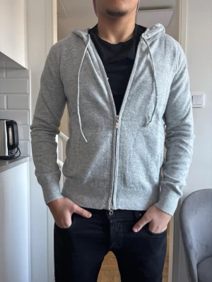 Grå Merinoull hoodie med dragkedja I storlek XS - Tjena, säljer denna as feta grå merinoull hoodie med dragkedja i storlek XS. Perfekt för sommaren. Inga skavanker eller några sorters skador på den alls. Bara att höra av sig om det är någonting som undras!