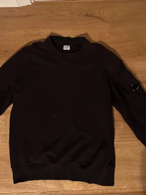 C.P Company tröja - Svart C.P crewneck i fint skick. Tröjan är sparsamt använd men har blivit aningen solblekt, men inget man tänker på direkt. Skriv om du har några frågor!