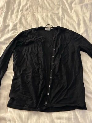 Svart kofta från Saint Tropez - Snygg svart kofta från Saint Tropez med knappar framtill. Står XL men den sitter som M.