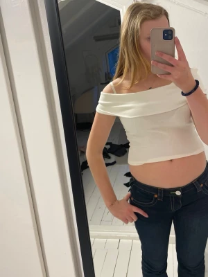 Vit offshoulder croppad topp Gina Tricot - En jätte snygg från gina tricot, har varit använd 1-2 gånger! Kan använda som en off shoulder och one shoulder! sitter jättefint på kroppen!❤️❤️❤️