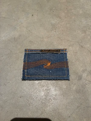 Plånbok i ptervunnet jeans -  Dropp 7  Handsydd plånbok i vintage jeans. Varje exemplar är unikt med snygga detaljer. Plånboken håller flera kort utan att dem åker ut. Små variationer i färg och struktur visar på plaggets tidigare historia💙  Tiktok: Jeanius.bc