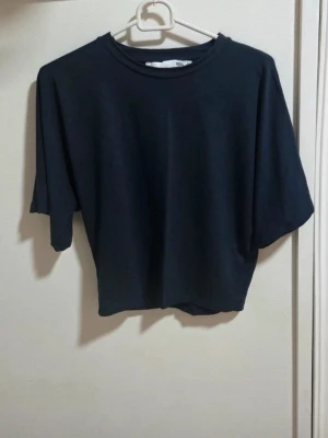 Mörkblå T-shirt Lager 157, Storlek M - Säljer en jättefin mörkblå topp från Lager 157 i storlek M. Toppen sitter snyggt, passar perfekt till midjehöga byxor eller kjolar.  Mått (platt liggande): Bredd (armhåla till armhåla): Ca 40 cm.        Längd (från axel och ner): Ca 44 cm.             Skick: Mycket fint skick