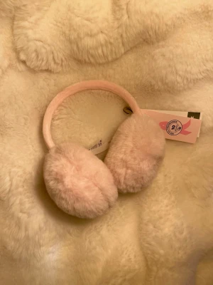 Ljusrosa fluffiga öronmuffar - Supersöta ljusrosa öronmuffar med mjuk, fluffig yta. Perfekta för att hålla öronen varma under kalla dagar. Bågen är också klädd i mjukt material för extra komfort. En söt accessoar som ger en mysig look. Nya med prislapp, nypris 129kr 💗