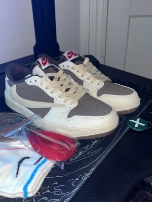 Jordan 1 Low "Reverse Mocha" - Stl 37.5 - Helt nya och oanvända. Säljes pga fel storlek vid beställning. • Storlek: 37.5 • Skick: 10/10 (oanvända) • Ingår: Tre par extra snören, strumpor och tillbehör enligt bild. Säljes för 800 kr då kvitto tyvärr inte finns kvar. Riktigt snygga skor som förtjänar att användas!  eller skickas spårbart. 