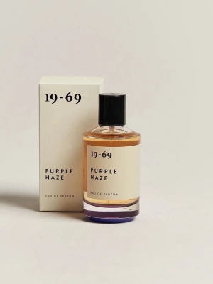 19-69 Purple Haze Eau de Parfum - Purple Haze Eau de Parfum från 19-69 kommer i en stilren, rund glasflaska med svart lock och minimalistisk vit etikett. Doften levereras i en matchande vit kartong med svart text. Perfekt för dig som gillar unika och moderna parfymer.
