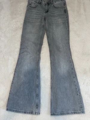 Grå bootcut jeans från 157 - Snygga grå bootcut jeans från 157 med låg midja. Jeansen har klassisk femficksdesign och är tillverkade i denim. Perfekta för dig som gillar en avslappnad och trendig stil. Använda 1-2 gånger.