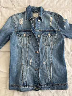 Jeans jacka - Säljer en riktigt schysst jeansjacka med feta slitningar, perfekt till våren. Jackan är i bra skick och har inte använts så mycket. Hör gärna av er vid frågor