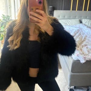 Svart fuskpälsjacka från H&M - Säljer en svart pälsjacka från H&M. Jackan har en rak passform och är öppen framtill utan synliga knappar. Perfekt för utekvällar eller bara när man vill klä upp sig lite extra 🤩