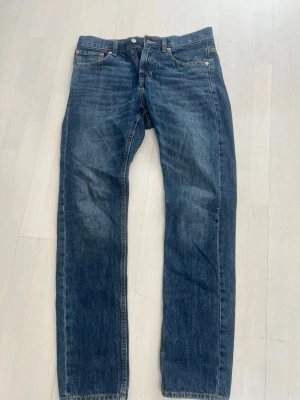 Klassiska blå jeans straight fit - Säljer ett par klassiska blå jeans från med rak passform och storlek 29 32. Perfekta för en avslappnad och tidlös stil. Materialet är robust denim i bomull.