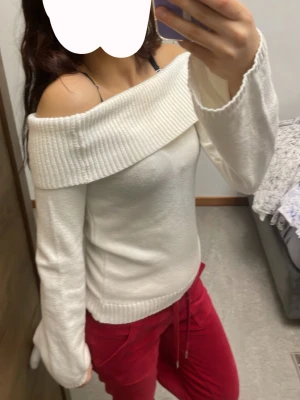 Vit off shoulder stickad tröja - Säljer en snygg vit stickad tröja med bred off shoulder-krage och långa ärmar. Tröjan har ribbstickade detaljer vid kragen och nederkanten, vilket ger en cool och modern look. Perfekt för dig som gillar trendiga och bekväma plagg.