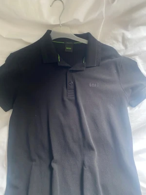 Hugo boss pike svart - Hej säljer denna boss piké, använt ett fåtal gånger, inga skador eller stora tecken på användning. Pris kan diskuteras 